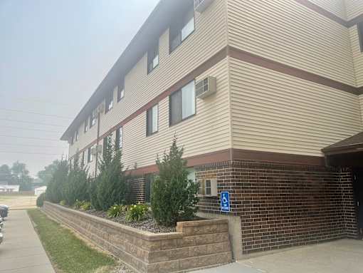 A building with a blue handicap sign on the wall.
