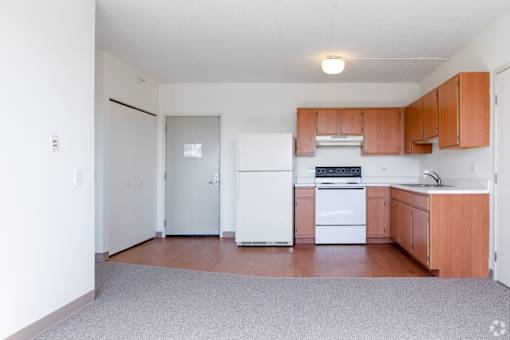 A kitchen with white appliances and wooden cabinets.
