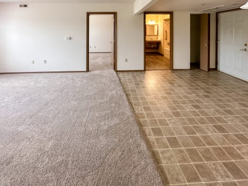 the living room and dining room of a new home with a carpet and tile floor