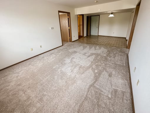 the living room and dining room of an empty apartment
