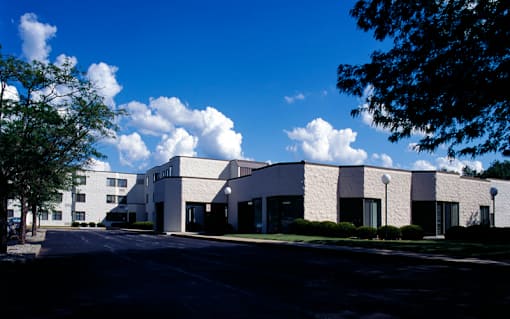 A white building with a parking lot in front.