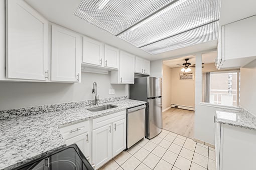 A kitchen with white cabinets and granite countertops.