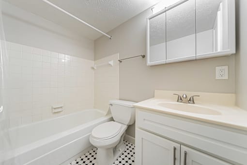 A white bathroom with a toilet, sink, and bathtub.