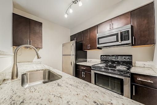 A kitchen with a sink, stove, and refrigerator.