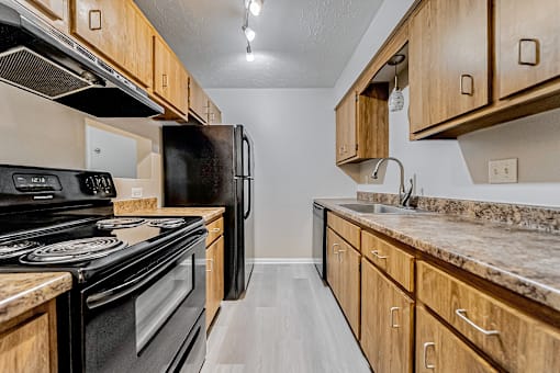 Galley kitchen with light wood cabinetry.