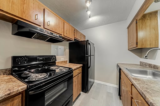 A kitchen with a black stove and refrigerator.