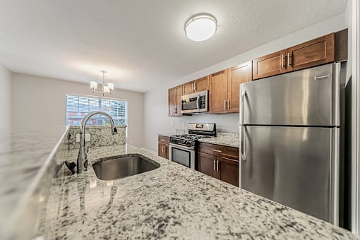 Townhome updated kitchen with granite counters and stainless steel appliances.