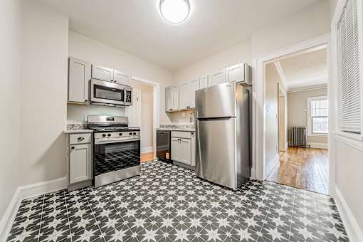 A kitchen with a black and white tiled floor.