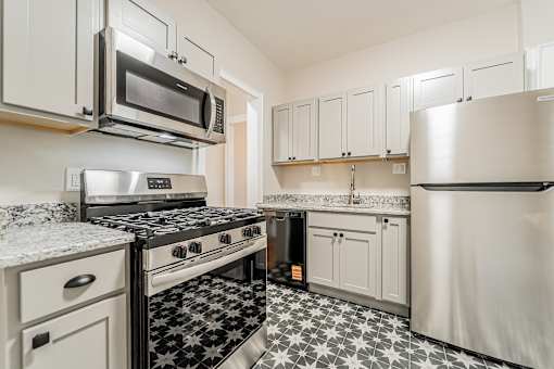 Updated kitchen with stainless steel appliances and a black and white floor. at Integrity Gold Coast Apartments, Apartments, Cleveland, OH