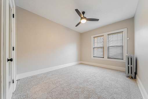 Carpeted bedroom with modern ceiling fan.