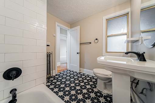 A white sink with a black faucet in a bathroom.