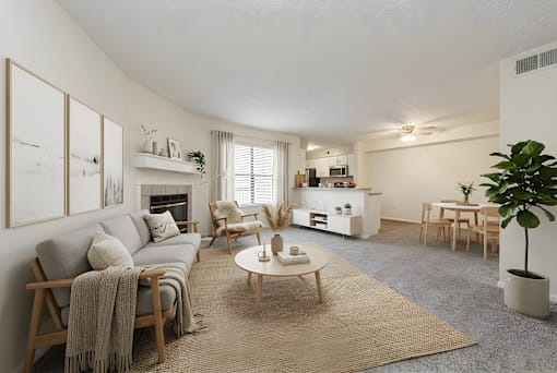 A living room with a grey couch, a wooden coffee table, and a rug at Hunt Club Apartments, Apartments, Copley, OH