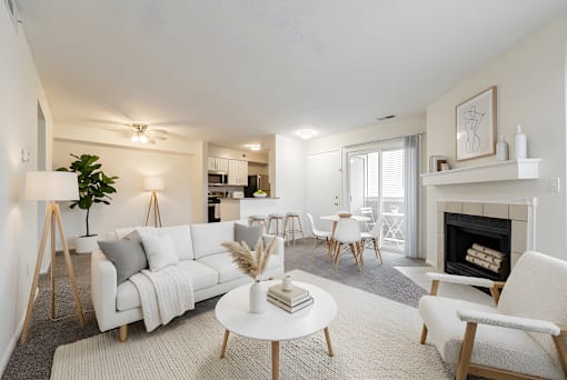 A living room with a white couch, a white coffee table, and a fireplace at Hunt Club Apartments, Copley, Ohio