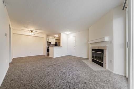 A spacious living room with a fireplace and a ceiling fan at Hunt Club Apartments, Copley