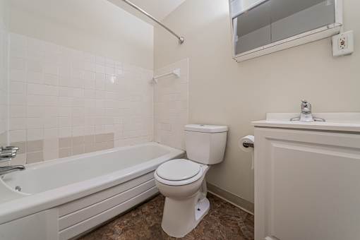 A white toilet sits next to a bathtub in a bathroom. at Integrity Berea Apartments, Ohio, 44017