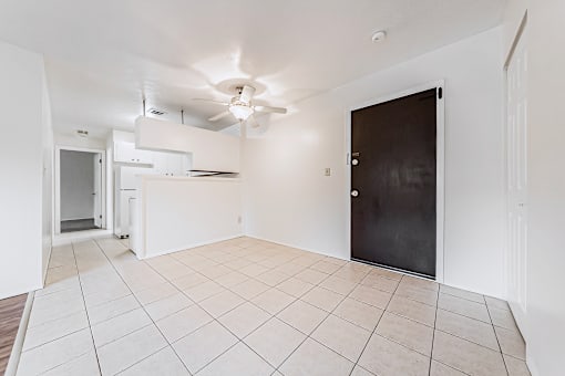A room with a black door and a ceiling fan.