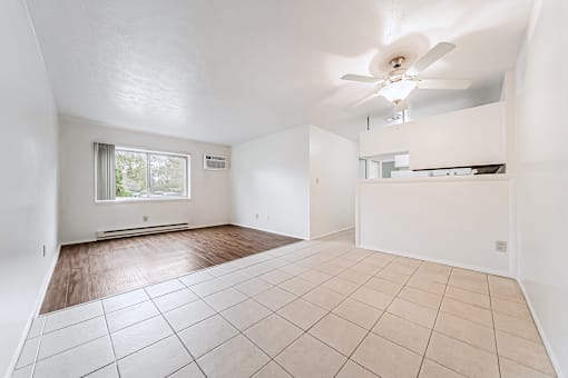 Empty room with a ceiling fan and tiled floor.
