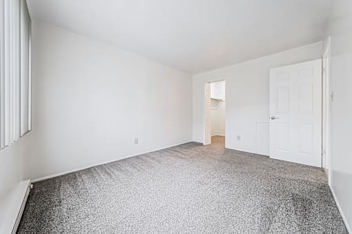 A room with a grey carpet and white walls.
