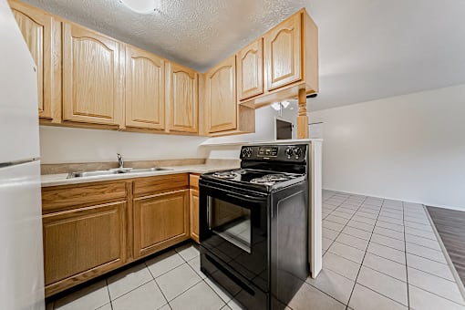 A kitchen with wooden cabinets and a black oven.
