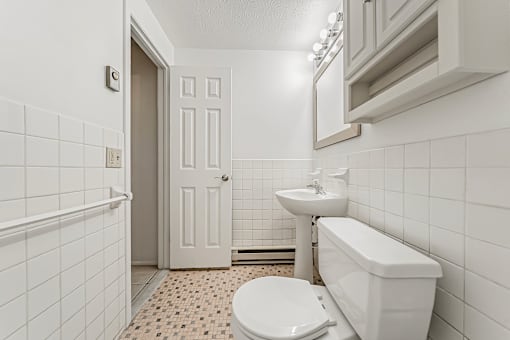 A white bathroom with a toilet, sink, and bathtub.