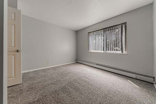 A room with a carpeted floor and a window with bars on it. at Integrity Berea Apartments, Berea, 44017