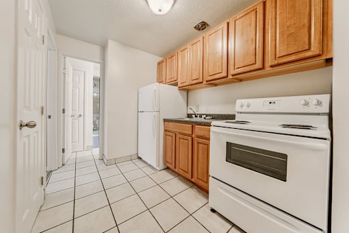 A kitchen with white appliances and wooden cabinets. at Integrity Berea Apartments, Ohio, 44017