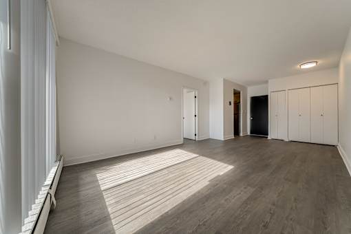 A room with wooden flooring and white walls.