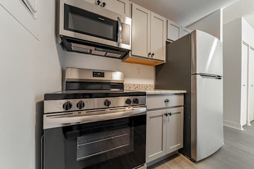 A modern kitchen with a stove, oven, microwave, and refrigerator.
