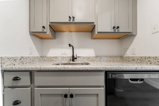 A modern kitchen with a granite countertop and stainless steel appliances.