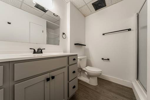 A bathroom with a toilet, sink, and a towel bar.