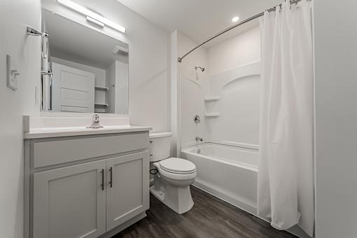 A white bathroom with a toilet, sink, and bathtub.