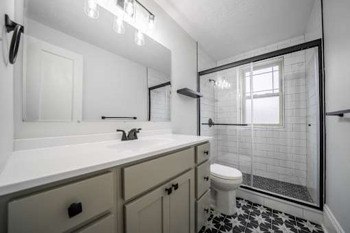 A white sink with a black and white tiled floor.at Integrity Cleveland Heights Apartments, Cleveland Heights