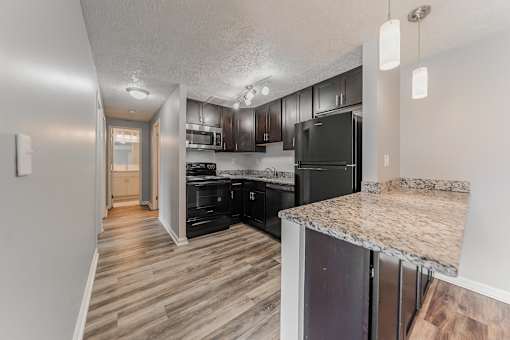 A kitchen with black appliances and wooden floors. at Integrity Berea Apartments, Berea, 44017