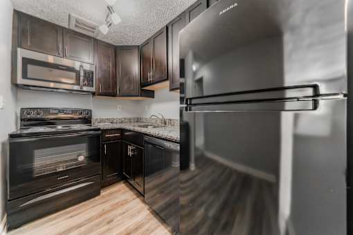 A kitchen with black cabinets and a stainless steel refrigerator. at Integrity Berea Apartments, Apartments, Berea, OH