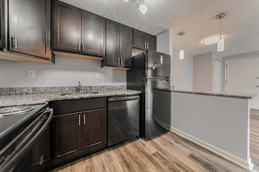 A kitchen with black cabinets and a stainless steel refrigerator. at Integrity Berea Apartments, Berea, OH, 44017