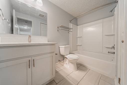 A white bathroom with a toilet, sink, and bathtub. at Integrity Berea Apartments, Berea, Ohio
