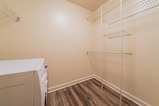 A laundry room with a washer and dryer and a shelf. at Integrity Berea Apartments, Berea, Ohio