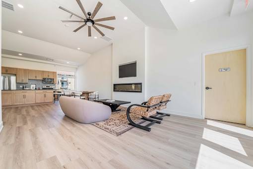 A modern living room with a brown ceiling fan and lighting.