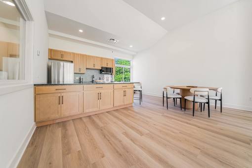 A kitchen with wooden floors and cabinets.