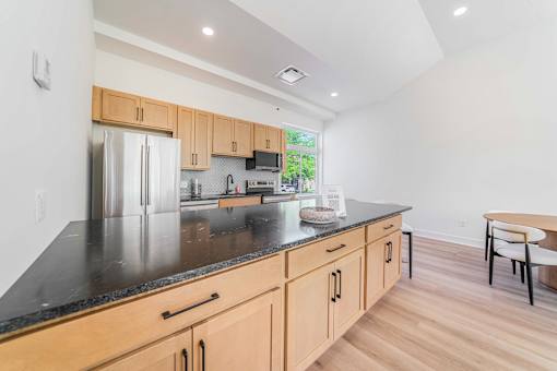 A kitchen with wooden cabinets and a black countertop.