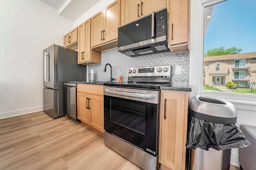 A kitchen with wooden cabinets and stainless steel appliances.