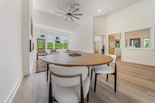 A dining room with a round table and chairs.