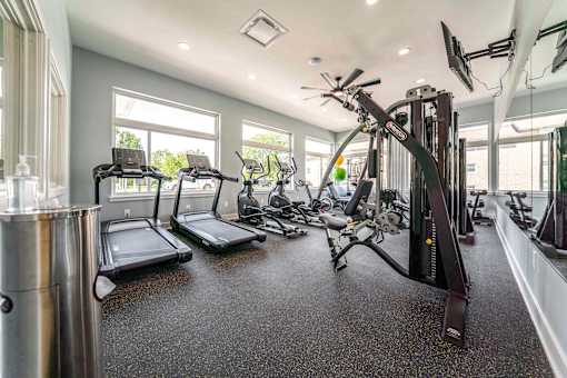 A spacious home gym with treadmills, elliptical machines, and other exercise equipment.