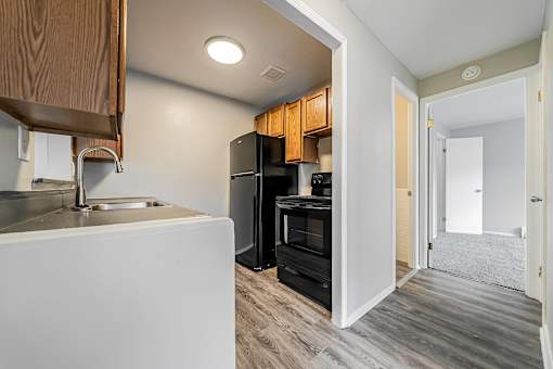 A kitchen with a sink, refrigerator, and cabinets at Integrity Chardon Apartments, Chardon, OH,  44024