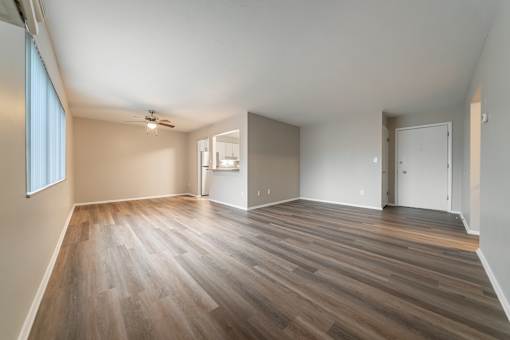 A room with wooden flooring and a ceiling fan.