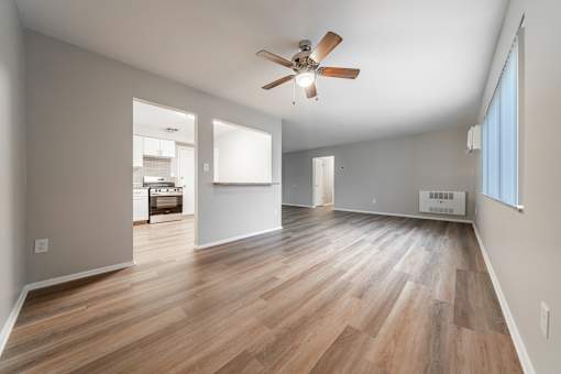 A room with a ceiling fan and wooden flooring.