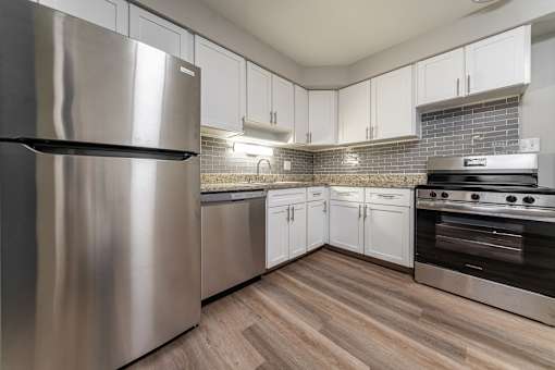 A modern kitchen with a stainless steel refrigerator and oven.
