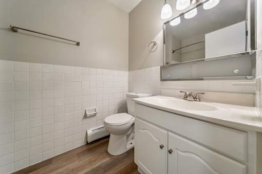 A white toilet sits next to a white sink in a bathroom.