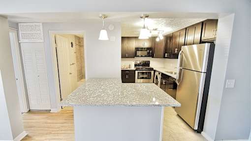 A kitchen with a granite countertop and stainless steel appliances. at Integrity Berea Apartments, Berea, Ohio