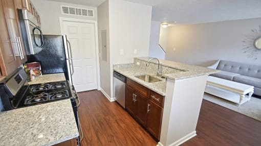 Townhome galley kitchen with granite countertops and a dishwasher.